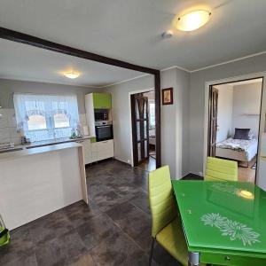eine Küche und ein Esszimmer mit einem grünen Tisch und Stühlen in der Unterkunft Guesthouse Kiljan in Blönduós