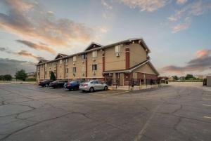 un grand bâtiment avec des voitures garées dans un parking dans l'établissement Super 8 by Wyndham Kenosha/Pleasant Prairie, à Pleasant Prairie