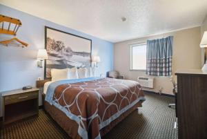 Cette chambre comprend un grand lit et une fenêtre. dans l'établissement Super 8 by Wyndham Kenosha/Pleasant Prairie, à Pleasant Prairie