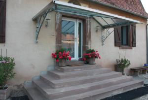 ein Haus mit einer Treppe, die zu einer Tür mit Blumen führt in der Unterkunft Chez Sabine et Laurent in Saverne