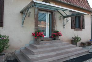 a house with stairs leading to a door with flowers at Chez Sabine et Laurent in Saverne