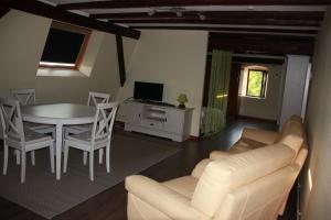 ein Wohnzimmer mit einem Sofa, einem Tisch und Stühlen in der Unterkunft Chez Sabine et Laurent in Saverne