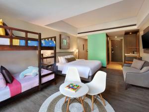 a room with two bunk beds and a couch at Mercure Bali Legian in Legian