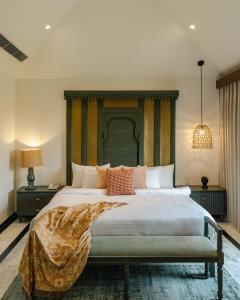 a bedroom with a large bed with a blanket on it at Surpura Bagh in Jodhpur