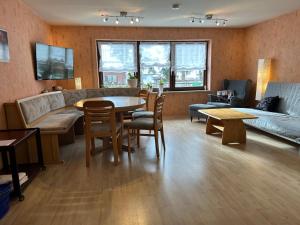 BachhagelにあるFerienwohnung Eva mit Blick ins Grüneのソファとテーブルと椅子のあるリビングルーム