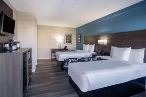 a hotel room with two beds and a television at La Quinta Inn by Wyndham Sacramento North in Sacramento