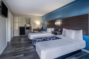 two beds in a hotel room with blue walls at La Quinta Inn by Wyndham Sacramento North in Sacramento