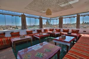 una grande stanza con divani, tavoli e finestre di Dar Borj a Fes