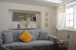 a blue couch with a yellow pillow in a living room at Studio in pieno centro in Capri