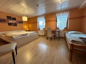 BachhagelにあるFerienwohnung Eva mit Blick ins Grüneのベッドルーム1室(ベッド2台、テーブル付)、ダイニングルームが備わります。