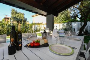 una mesa con un plato de comida y botellas de vino en MGH Luxury - Villa Celeste, en Desenzano del Garda