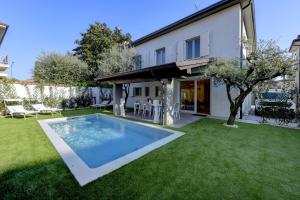 un patio trasero con piscina y una casa en MGH Luxury - Villa Celeste, en Desenzano del Garda