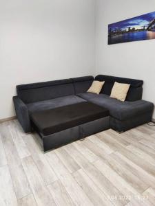 a black leather couch in a living room at Lovely condo in the heart of Warsaw Piękne mieszkanie w samym sercu Warszawy in Warsaw