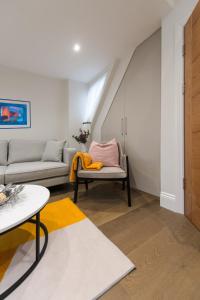 a living room with a couch and a chair at Ealing Residency in London