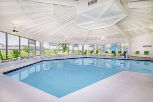 a large swimming pool in a building with a large ceiling at Hawthorn Extended Stay by Wyndham Wichita Airport in Wichita