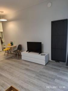 a living room with a flat screen tv on a white cabinet at Lovely condo in the heart of Warsaw Piękne mieszkanie w samym sercu Warszawy in Warsaw