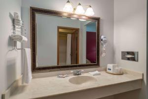 a bathroom with a sink and a mirror at Travelodge by Wyndham Merrill in Merrill +27 photos