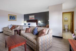 a living room with a couch and a bedroom at Travelodge by Wyndham Merrill in Merrill