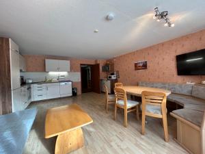 een keuken en een woonkamer met een tafel en stoelen bij Ferienwohnung Eva mit Blick ins Grüne 
