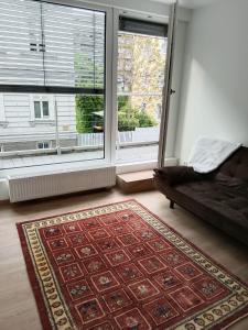 Habitación con alfombra, cama y ventanas en LiNZ CITY SUITE en Linz