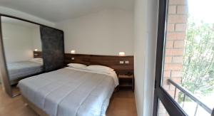 ein Schlafzimmer mit einem Bett und einem großen Fenster in der Unterkunft BRIXELLUM in Brescello