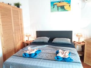 1 dormitorio con 1 cama con 2 toallas en Porto Antigo Holidays, en Santa Maria