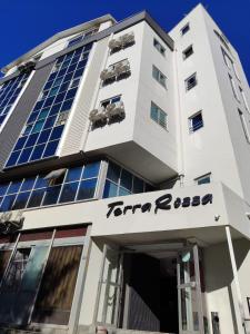 een hoog wit gebouw met een bord erop bij Terra Rossa in Antalya