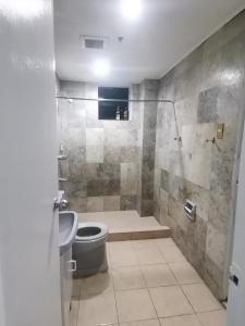 uma casa de banho com um chuveiro, um WC e um lavatório. em Accommodation services-anne em Manila
