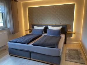 um quarto com uma cama grande e almofadas azuis em Ferienhaus Amare mit eigener Terrasse, Sauna & Kamin em Bautzen
