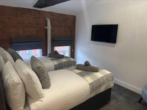 duas camas num quarto com uma televisão na parede em Cosy City Escape em Hull