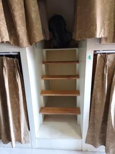 a bookcase with stairs in a room with curtains at Chiangmai Delight Hostel in Chiang Mai