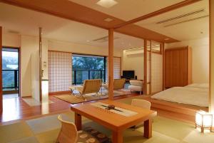 
a bedroom with a bed, desk, chair and a tv at Hakone Tokinoshizuku in Hakone
