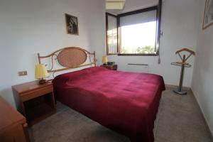 ein Schlafzimmer mit einem roten Bett und einem Fenster in der Unterkunft Casa Mare Vienna in Follonica