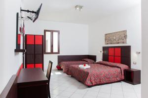 1 dormitorio con 2 camas y mesa. en Resort Villa Hermosa, en Porto Cesareo