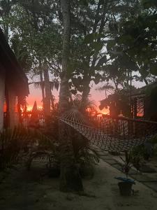 una hamaca en una playa con una puesta de sol en el fondo en Alleppey Beach Garden en Alleppey