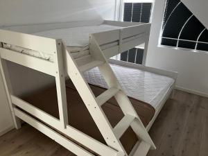 a white bunk bed in a room with a window at Stor hytte på Åros feriesenter in Kristiansand