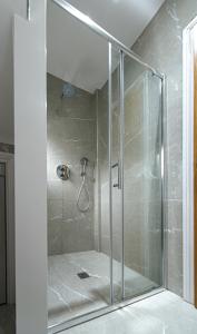 a shower with a glass door in a bathroom at Ealing Residency in London