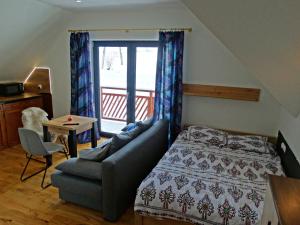 ein Schlafzimmer mit einem Bett, einem Sofa und einem Tisch in der Unterkunft Apartamenty Widokówka in Grywałd