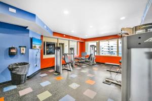 a gym with several treadmills and chairs in a room at Shores of Panama 1003 in Panama City Beach