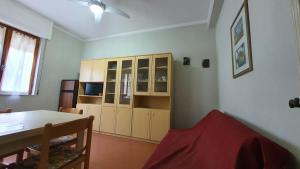ein Wohnzimmer mit einem Tisch und einem Schrank in der Unterkunft Casa sud fronte mare in Follonica