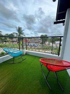 two chairs on a balcony with green grass at LA Villa Private Pool Kuantan in Kuantan