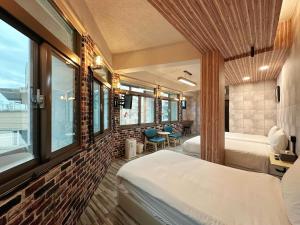 Habitación de hotel con 2 camas y ventanas en 達魯瑪民宿-無停車位, en Hualien City