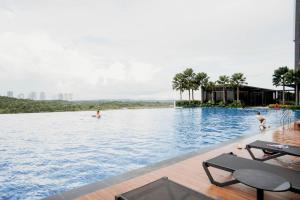 a swimming pool with people in the water at Stylish Loft Duplex Sunway Grid by Our Stay in Kampong Pendas