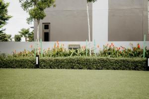 a field of grass with flowers in front of a building at Stylish Loft Duplex Sunway Grid by Our Stay in Kampong Pendas