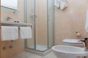 e bagno con doccia, servizi igienici e lavandino. di Resort Villa Hermosa a Porto Cesareo