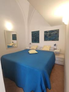 a bedroom with a blue bed in a white room at Studio in pieno centro in Capri