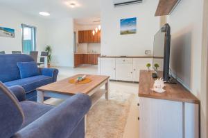 a living room with a blue couch and a table at Lavender Bay Apartment in Donji Morinj