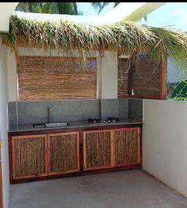 a kitchen with a sink and a straw roof at Siargao Residency by Privacy Group in General Luna