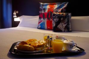 una bandeja de comida para el desayuno y dos vasos de zumo de naranja en Hotel Apartamentos Rock Star, en Taboadela