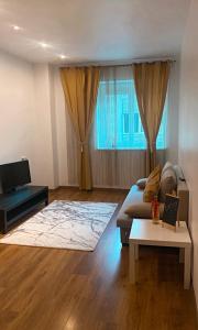 ein Wohnzimmer mit Sofa und Fernseher in der Unterkunft DMT Apartament regim hotelier Rin in Bukarest